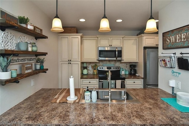 kitchen featuring stainless steel appliances, decorative light fixtures, and cream cabinetry