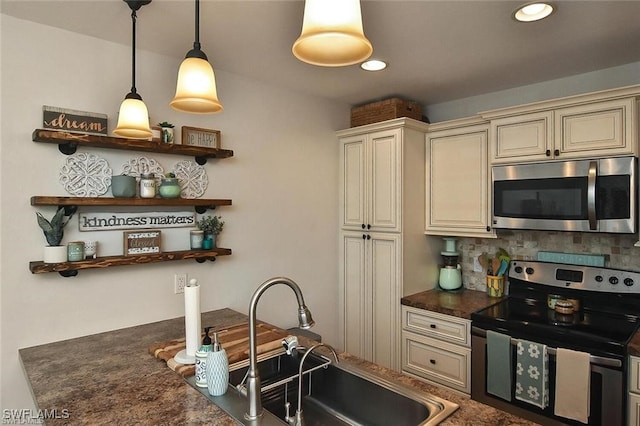 kitchen featuring sink, hanging light fixtures, backsplash, stainless steel appliances, and cream cabinetry