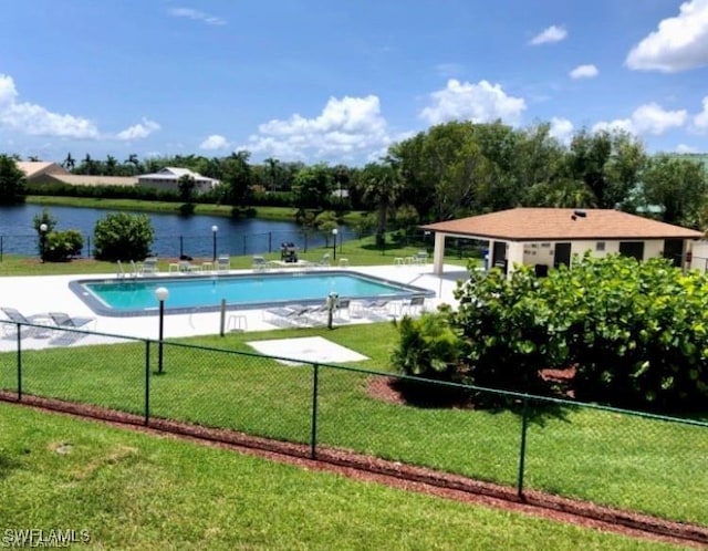 view of swimming pool featuring a water view and a yard