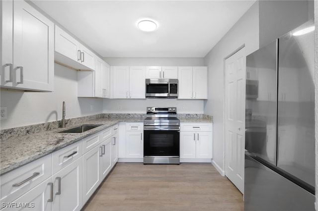 kitchen with white cabinetry, stainless steel appliances, and sink