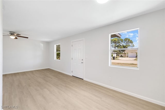 empty room with ceiling fan and light hardwood / wood-style floors