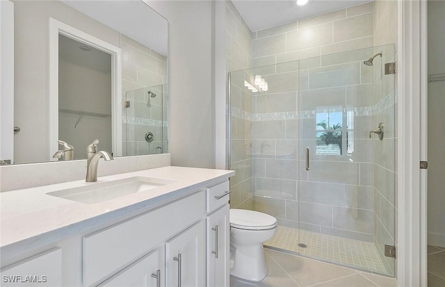 bathroom featuring vanity, tile patterned floors, a shower with door, and toilet