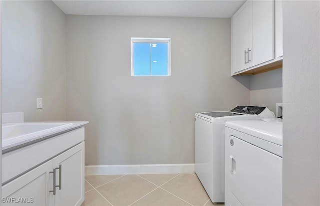 clothes washing area with light tile patterned floors, sink, cabinets, and washing machine and clothes dryer