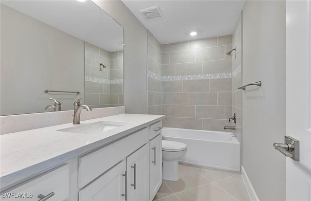 full bathroom with tiled shower / bath, vanity, toilet, and tile patterned flooring