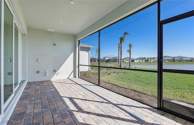 unfurnished sunroom with a water view