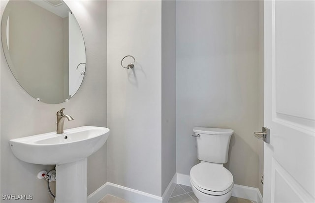 bathroom featuring toilet and tile patterned flooring