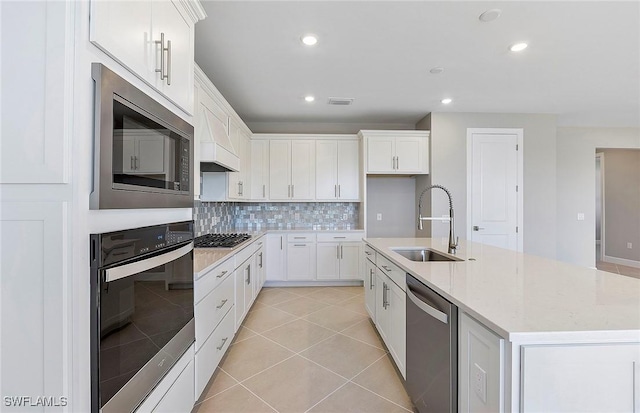 kitchen with white cabinetry, sink, decorative backsplash, a kitchen island with sink, and stainless steel appliances