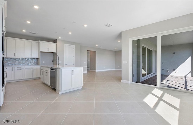 kitchen with dishwasher, white cabinetry, a kitchen island with sink, and light tile patterned flooring