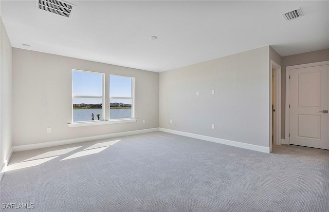 carpeted empty room with a water view