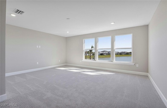 carpeted spare room with a water view