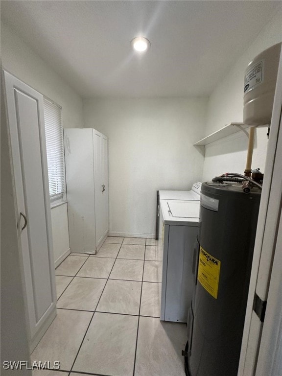 laundry room featuring light tile patterned floors, water heater, and independent washer and dryer