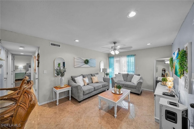 tiled living room featuring heating unit and ceiling fan