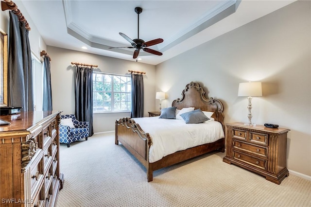 carpeted bedroom with crown molding, ceiling fan, and a tray ceiling