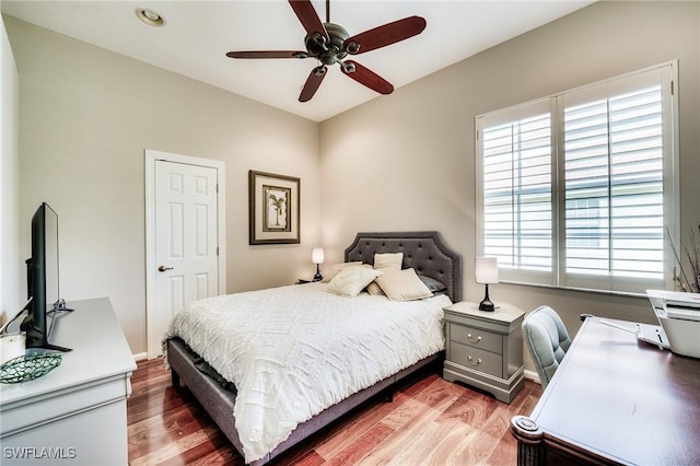 bedroom with multiple windows, wood-type flooring, and ceiling fan