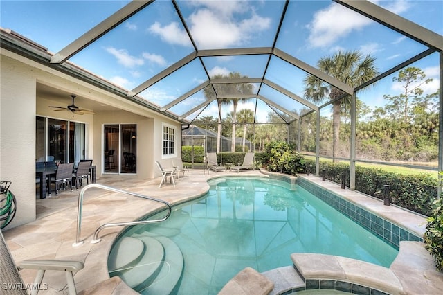 view of swimming pool featuring a patio, ceiling fan, and glass enclosure