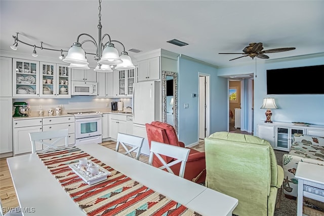 kitchen featuring white appliances, visible vents, white cabinets, light wood-style flooring, and crown molding