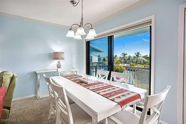 dining space featuring carpet floors, a notable chandelier, baseboards, and crown molding