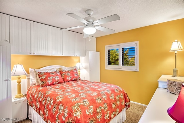 carpeted bedroom with a textured ceiling, ceiling fan, and baseboards