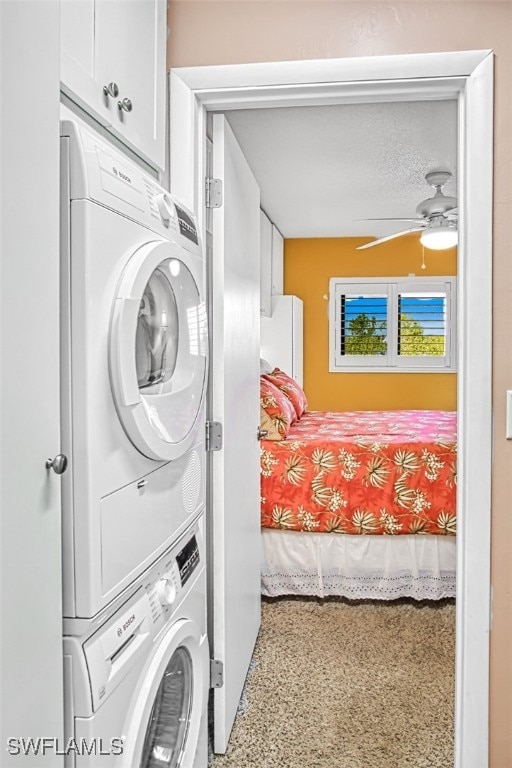 washroom with stacked washer / dryer, cabinet space, and ceiling fan