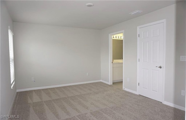 unfurnished room featuring light colored carpet