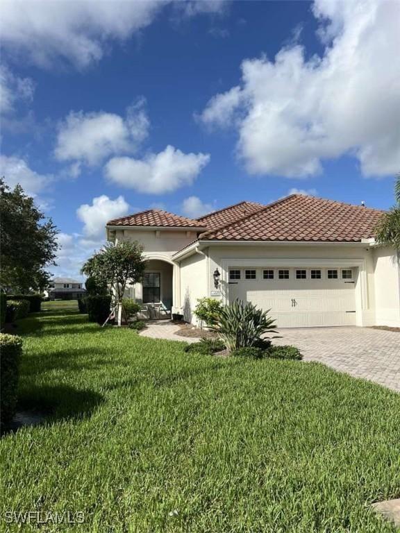 mediterranean / spanish house with a garage and a front yard