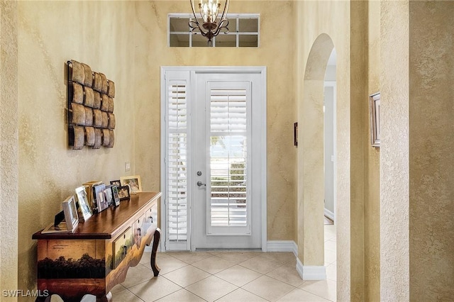 tiled foyer with a chandelier