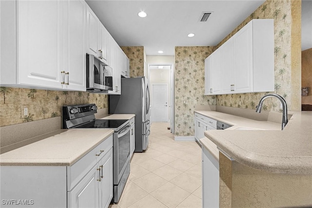 kitchen with white cabinetry, sink, light tile patterned floors, and appliances with stainless steel finishes