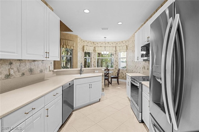 kitchen featuring pendant lighting, white cabinets, and appliances with stainless steel finishes