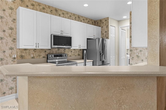 kitchen featuring stainless steel appliances, white cabinets, and kitchen peninsula