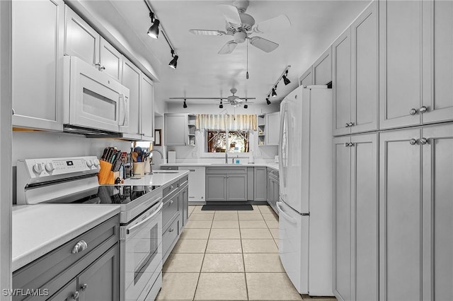 kitchen with sink, gray cabinetry, light tile patterned floors, ceiling fan, and white appliances