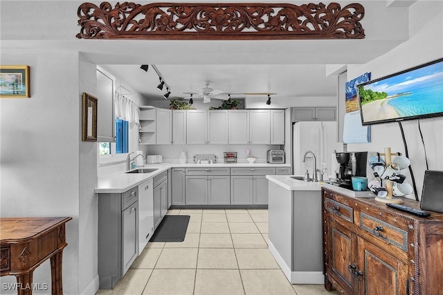 kitchen featuring sink, light tile patterned floors, dishwasher, gray cabinetry, and white fridge