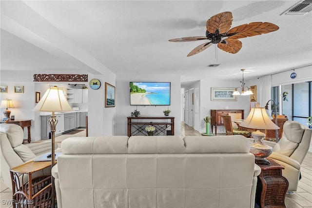 living room with hardwood / wood-style flooring and ceiling fan with notable chandelier