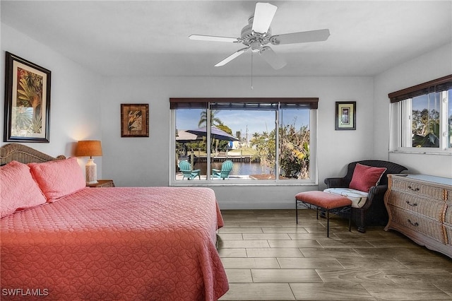 bedroom featuring a water view and ceiling fan