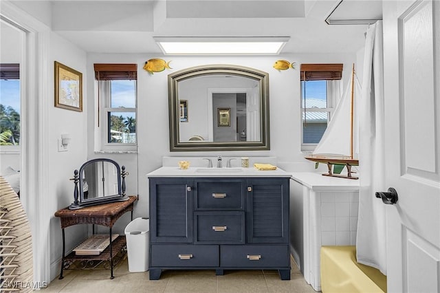 bathroom with tile patterned flooring, vanity, and a bathtub