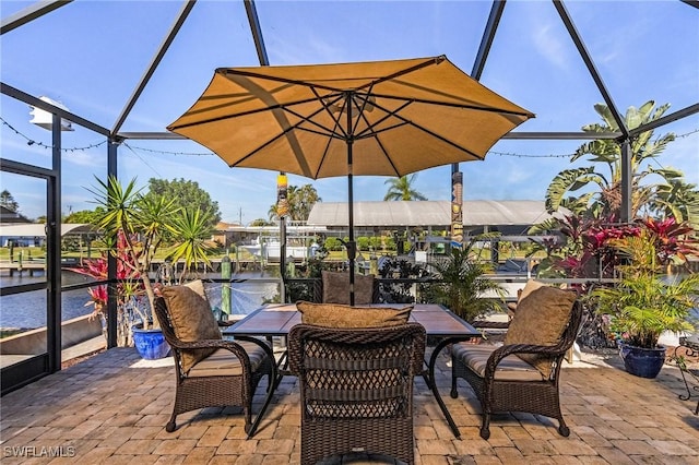 view of patio featuring a water view and glass enclosure