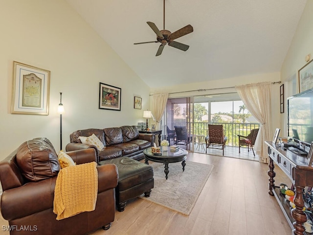 living room with ceiling fan, high vaulted ceiling, and light wood-type flooring