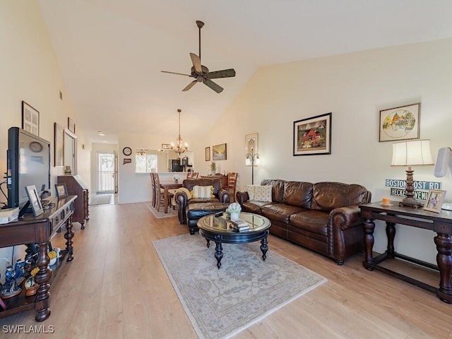 living room featuring high vaulted ceiling, ceiling fan with notable chandelier, and light hardwood / wood-style floors