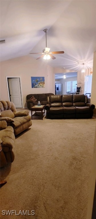 living room with lofted ceiling, ceiling fan, and carpet