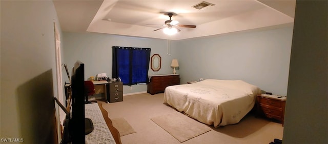 bedroom featuring ceiling fan, light colored carpet, and a raised ceiling