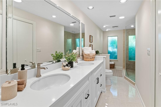 bathroom with tile patterned flooring, vanity, toilet, and a tile shower