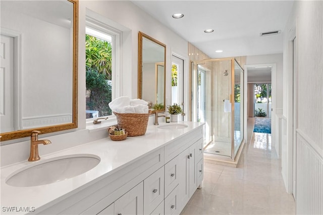 bathroom featuring vanity, a healthy amount of sunlight, and walk in shower