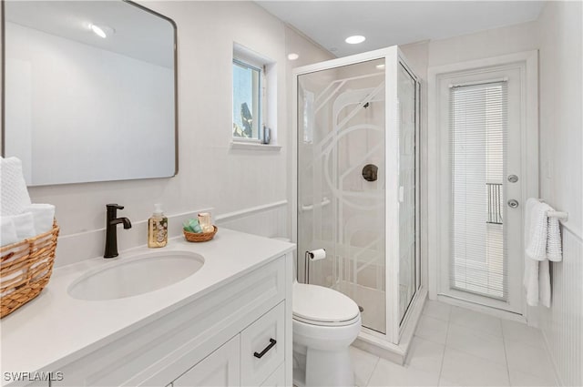 bathroom with vanity, a shower with shower door, tile patterned floors, and toilet