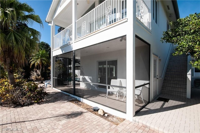 rear view of house with a patio area and a balcony