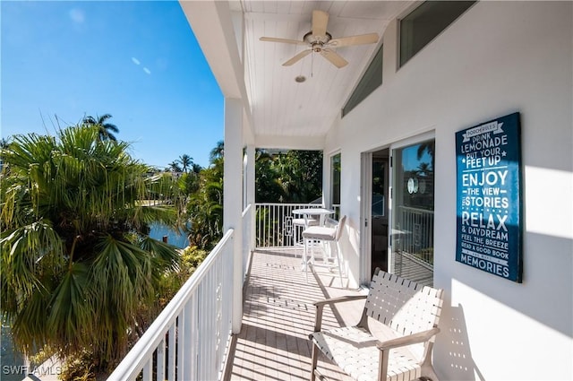 balcony with a water view and ceiling fan