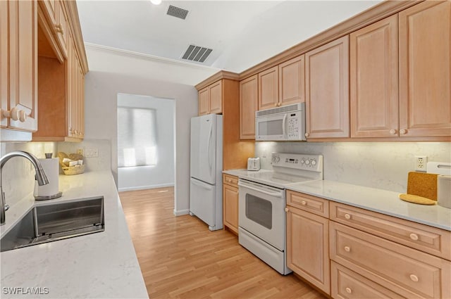 kitchen featuring white appliances, light brown cabinetry, light hardwood / wood-style floors, and sink