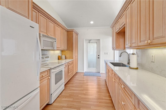 kitchen featuring sink, white appliances, light hardwood / wood-style floors, and backsplash