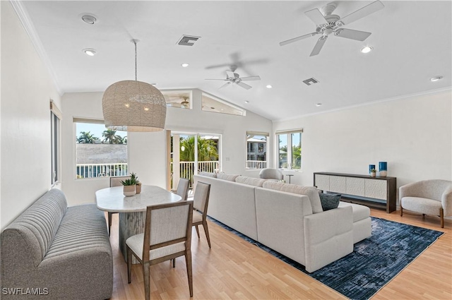 living room featuring crown molding, lofted ceiling, and light hardwood / wood-style flooring