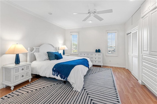 bedroom with crown molding, light hardwood / wood-style floors, a closet, and ceiling fan