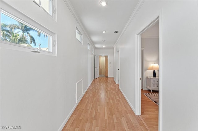 hall featuring ornamental molding and light hardwood / wood-style floors