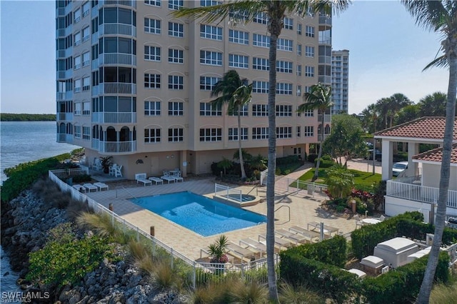 view of pool with a patio area and a water view